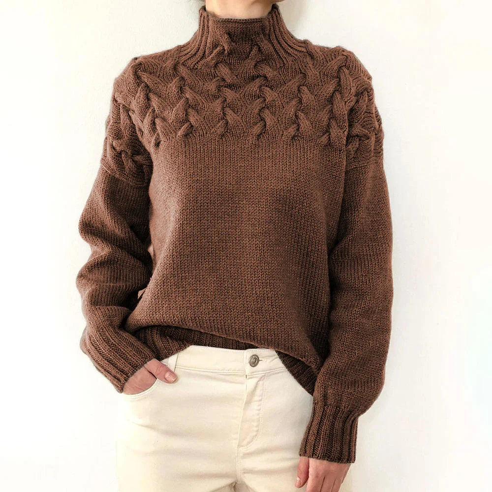 Woman wearing brown cable knit turtleneck sweater paired with high-waisted cream pants