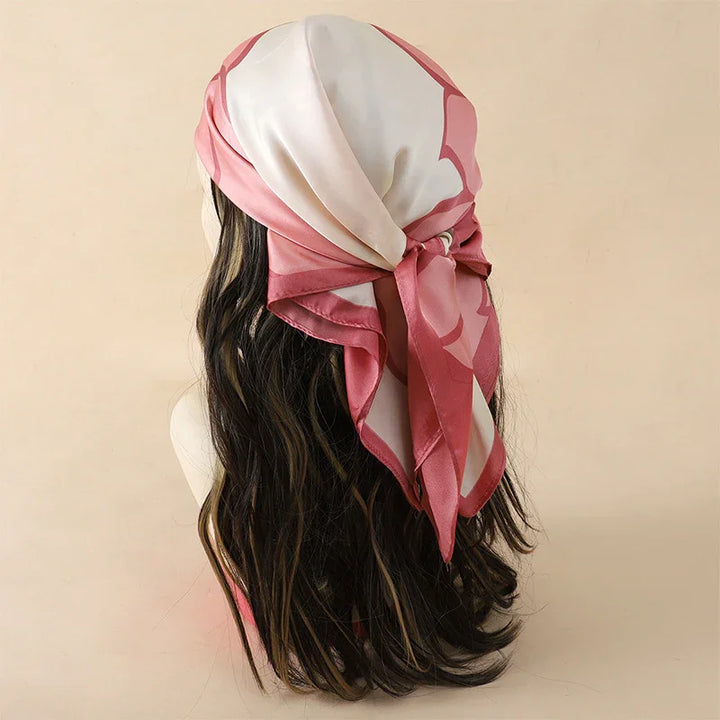 Silky pink and white patterned headscarf tied on mannequin with wavy brown hair